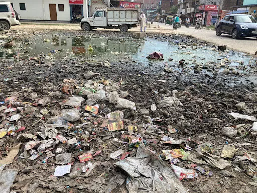 घनी आबादी राजातालाब बाज़ार में फेंका जा रहा हाईवे का कचरा, विरोध के बाद ट्रैक्टर लेकर भागे